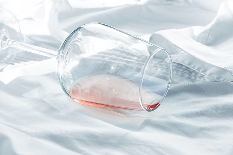 Glass, with pink wine, spilled on a white shirt, close-up, selective focus, no people, concept, top view