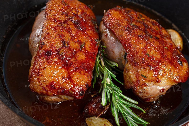 Roast duck breast, in a frying pan, with spices and herbs, close-up, no people