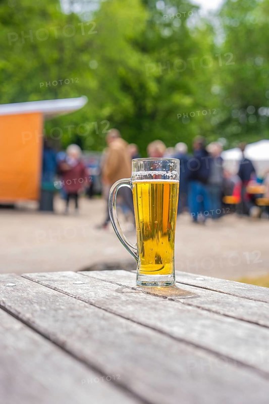 A glass of beer on an outdoor wooden table, with blurred background, Father's Day, Forest Festival, Aidlingen, Böblingen County, Germany