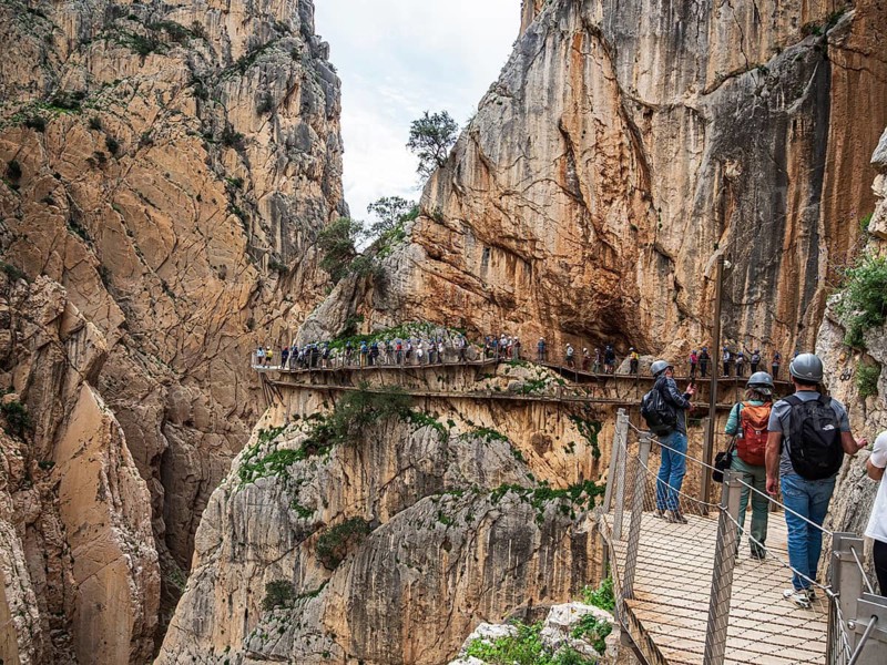 Tourists on the elevated path of the caminito del rey, along a deep gorge, Andalusia, Spain