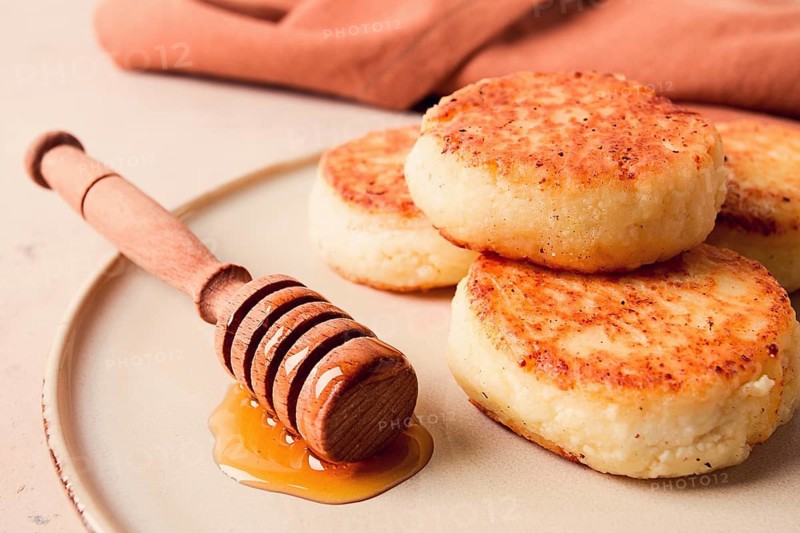 Cottage cheese pancakes, with honey, close-up, on a beige table, selective focus, no people