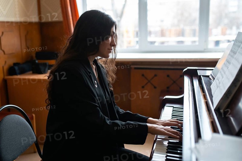 A pianist focuses intently on playing music beside a sunlit window The serene ambiance highlights the harmony of the notes, reflecting passion and dedication to the craft
