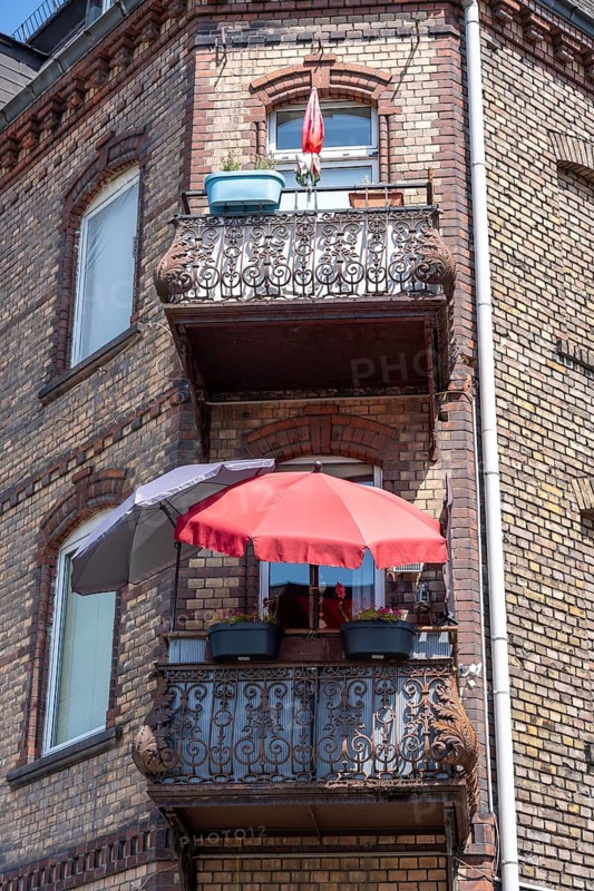 Residential building in the old town of Kaub, in the Upper Middle Rhine Valley World Heritage Site, balcony with metal decorations, red parasol, Rhineland-Palatinate, Germany