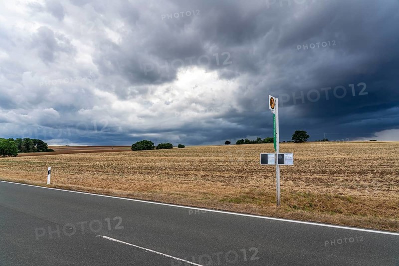Single stop of bus line 510 between Korbach and Bad Wildungen, country road near Waldeck in North Hesse, bus stop Abzweig Netze, bus traffic between 6 a.m. and 5 p.m., NVV, Nordhessische VerkehrsVerbund, thunderstorm front approaching, Germany