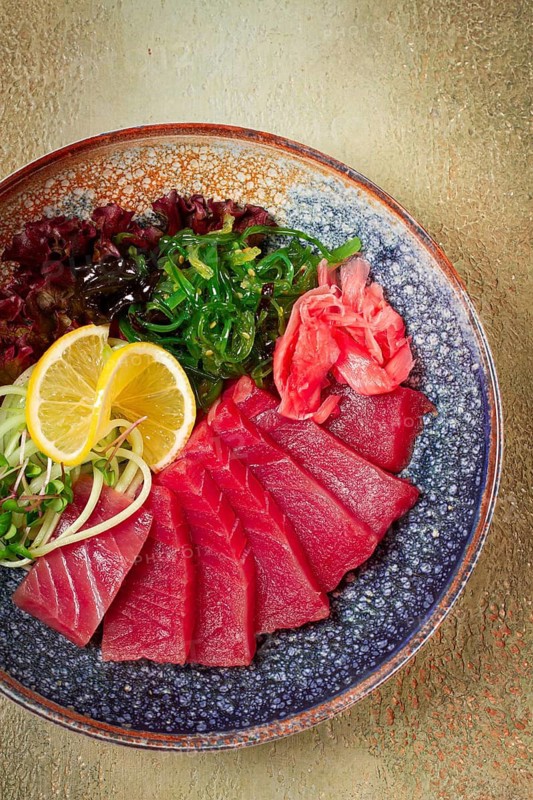 Tuna sashimi with daikon and wakame salad, pickled ginger, in a bowl