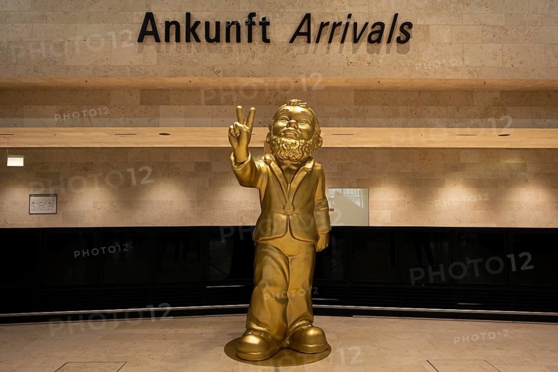 A giant golden garden gnome greets travelers and visitors in the arrivals area of the new Terminal 3 at Frankfurt Airport, Airport Terminal 3, Frankfurt am Main, Hesse, Germany