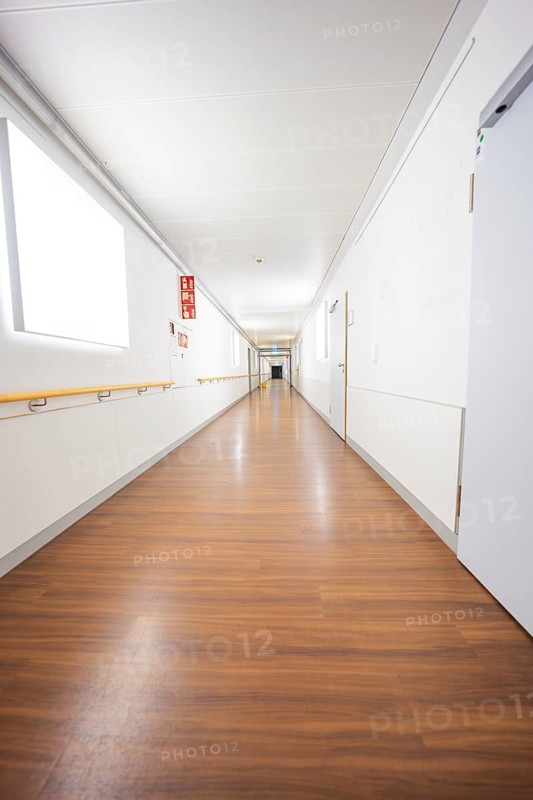 Long, bright corridor with wooden floors and minimalistic design, old disused hospital, Calw, Germany
