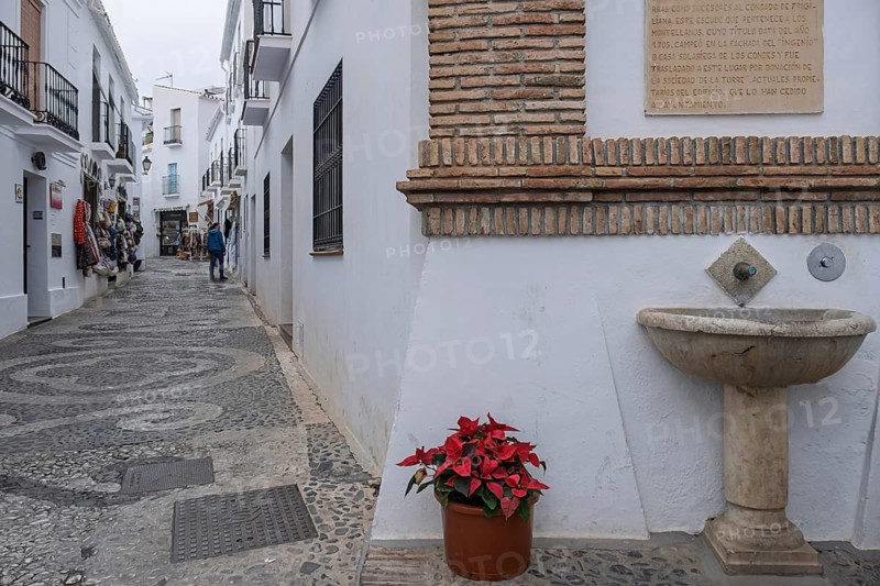 Alley and fountain in the white village of Frigiliana, Malaga province, Andalucia, Spain