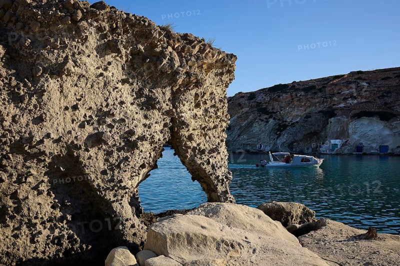 Elephant shaped rocks, rock formation with natural bridge over blue sea, boat nearby, Syrmata, boat garages, boathouse, boathouses, beach house, Goupa, Goypa, Goupa Kara, Kimolos, Cyclades, Greek Islands, Greece