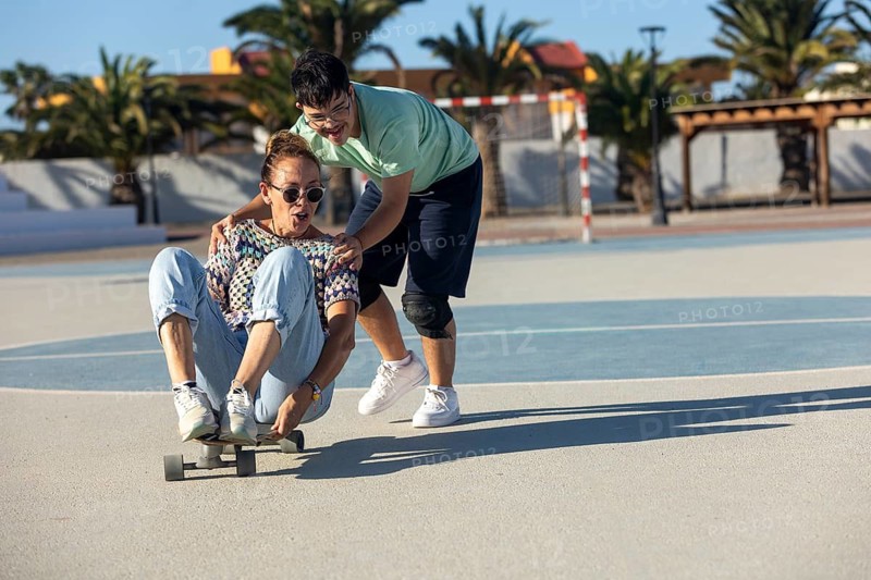 A joyful scene of a Down syndrome teenager participating in outdoor sports with family on a sunny day The image captures the spirit of family bonding and active lifestyle