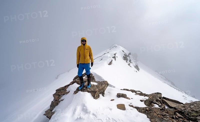 Ski tourer on the cloudy summit of Kesch Pitschen, Bündner Haute Route ski tour, Albula Alps, Rhaetian Alps, Grisons, Eastern Switzerland, Switzerland