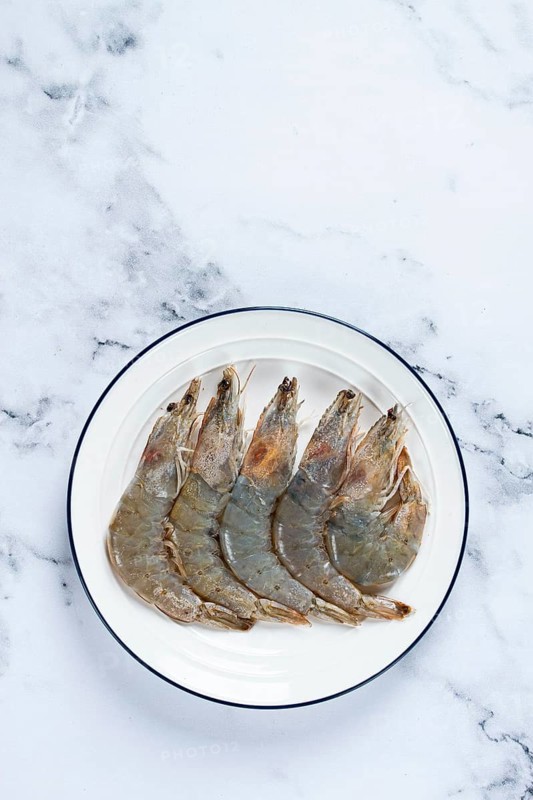 Fresh raw white-footed shrimp, tiger prawns vannamei, on a white plate