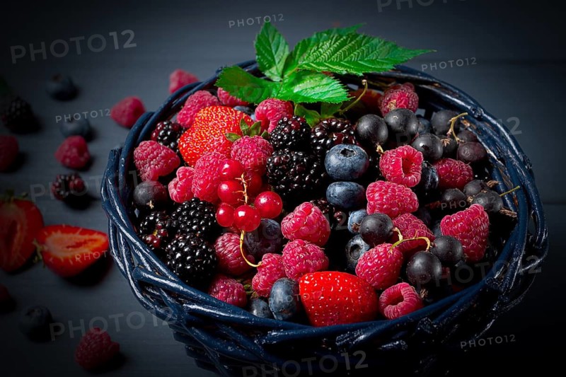 Mix of fresh berries, in a basket, on a wooden gray table, no people, top view