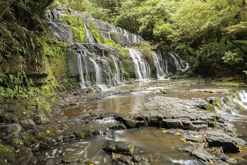 Waterfall of Purakaunui Falls in dense forest with rocks, Purakaunui, Owaka, New Zealand, Oceania