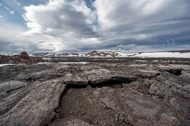 Petrified lava, lava fields and snow-covered volcanic landscape, crater of Askja volcano, Icelandic highlands, Iceland