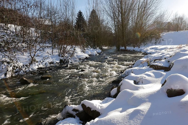 Dortmund, North Rhine-Westphalia, Germany - Sunny winter landscape in the Ruhr area, ice and snow on the renaturalised Emscher, the ecological conversion of the Emscher system consists of the construction of a central wastewater treatment system in the Ruhr area, the construction of underground sewers and the renaturalisation of the Emscher and its tributaries