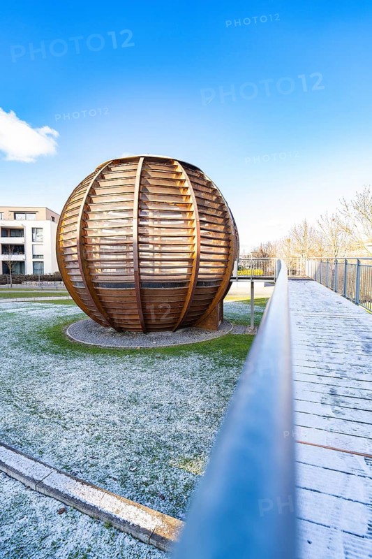 Large wooden sphere structure on grass, in the background modern buildings under a clear sky, forest sphere from Landesgartenschau 2012, Nagold, Black Forest, Germany