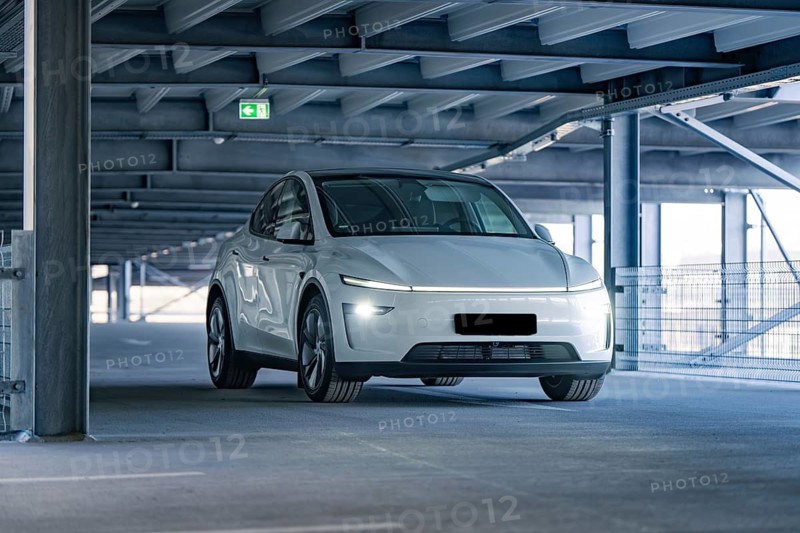 White electric car in a modern garage with steel beams, Tesla, New Model Y Juniper, Germany