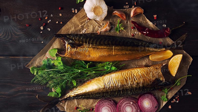 Smoked mackerel, top view, with spices, on a wooden table, no people, selective focus