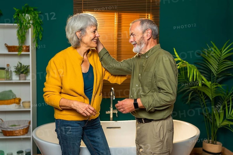 Side view of a modern romantic caucasian senior couple talking and caressing on the bathroom