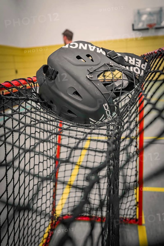 Black floorball helmet caught in a net in a sports hall, Foolball, Calw, Germany