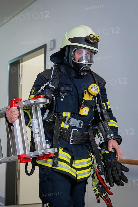 Firefighter with respirator and ladder in a building, fire department exercise on blue light day in the new Calw hospital, Germany