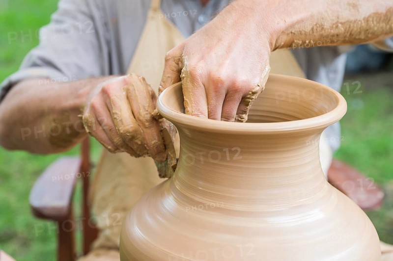 Hands of a man making a clay vase on a potter's wheel in Boleslawiec, Poland