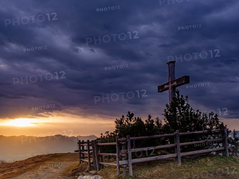 Summit cross on the Roßfeld under a dramatically overcast sky, the sun shines through a gap behind, Roßfeldpanoramastraße, Oberau, Berchtesgadener Land, Upper Bavaria, Bavaria, Germany