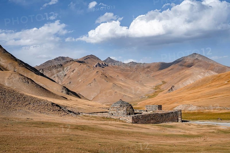 Historic caravanserai Tash Rabat from the 15th century, with yellow hills, Atbashy district in the Naryn region, Kyrgyzstan
