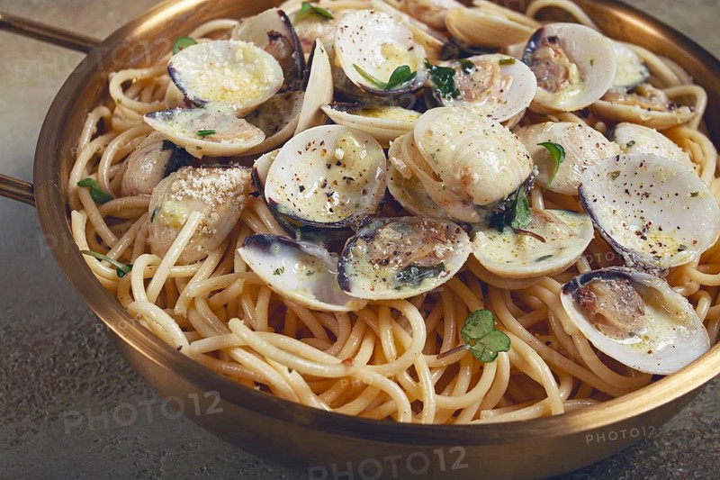 Spaghetti with vongole clams, in cream sauce, carbonara, in a brass pan, homemade, top view, no people