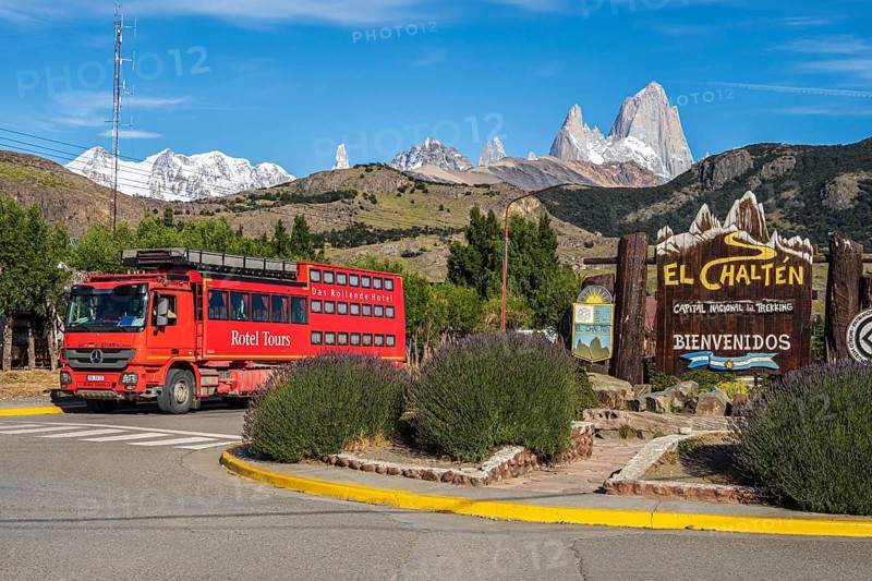 Welcome-sign at mountain village El Chalten, mountain range of Cerro Torre and Cerro Fitz Roy in the back, hotel bus, El Chalten, Argentina
