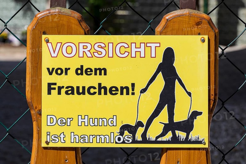Funny sign on a fence, beware of the mistress, the dog is harmless