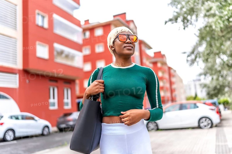 Frontal portrait of a beauty urban blonde african woman with handbag strolling in the city