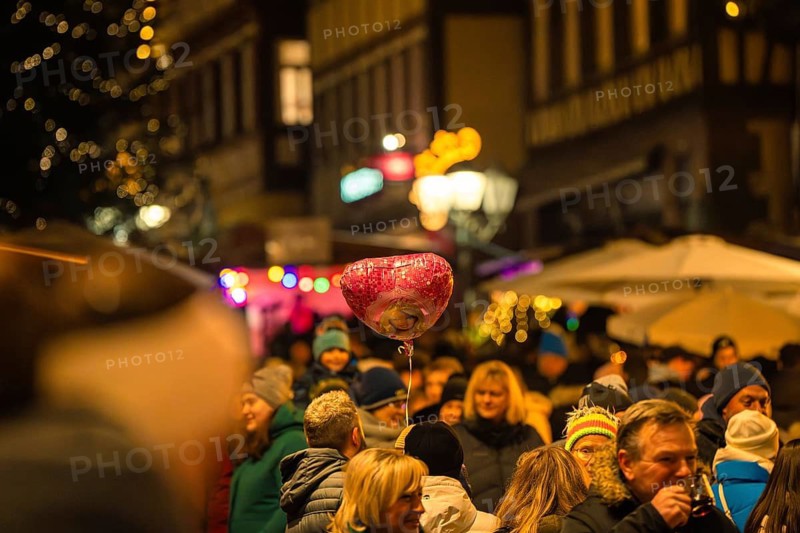 Lively night market with lots of people and a heart-shaped balloon above the crowd, Christmas market Calw, Black Forest, Germany