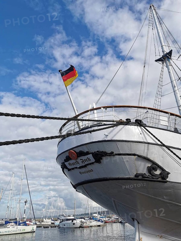 Bow of the sailing ship Gorch Fock, in Stralsund harbour with blowing wind and clearly visible German flag, Stralsund, Germany