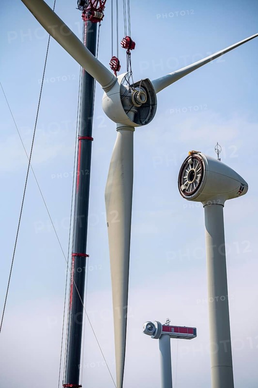Dismantling of a wind power plant in a wind farm near Issum, 9 older wind turbines from the manufacturer Enercon (model series E-58), front, blades being dismantled, were in operation for over two decades, will be replaced by a total of four Enercon E-160 turbines, rear, assembly of the first blade, with a total output of 22 megawatts, Lower Rhine, North Rhine-Westphalia, Germany