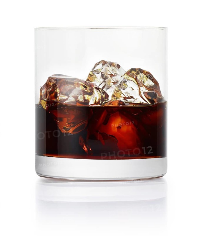 Drink on ice cube cubes in a tumbler in front of a white background, studio shot