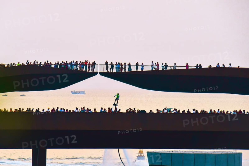 Phu quoc, Vietnam - 15th february, 2024: Crowd of spectators tourist on Kiss bridge during water show on Sunset town in Phu Quoc, Vietnam. Hoverboard show performance in public
