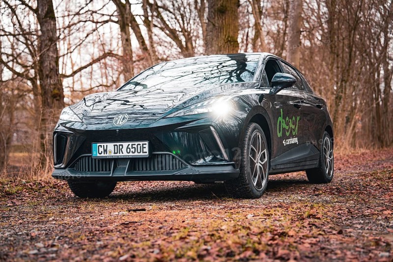 Black car parked on a leaf-covered forest path under a cloudy sky, e-car sharing vehicle from Deer Mobility, Gechingen, Black Forest, Germany