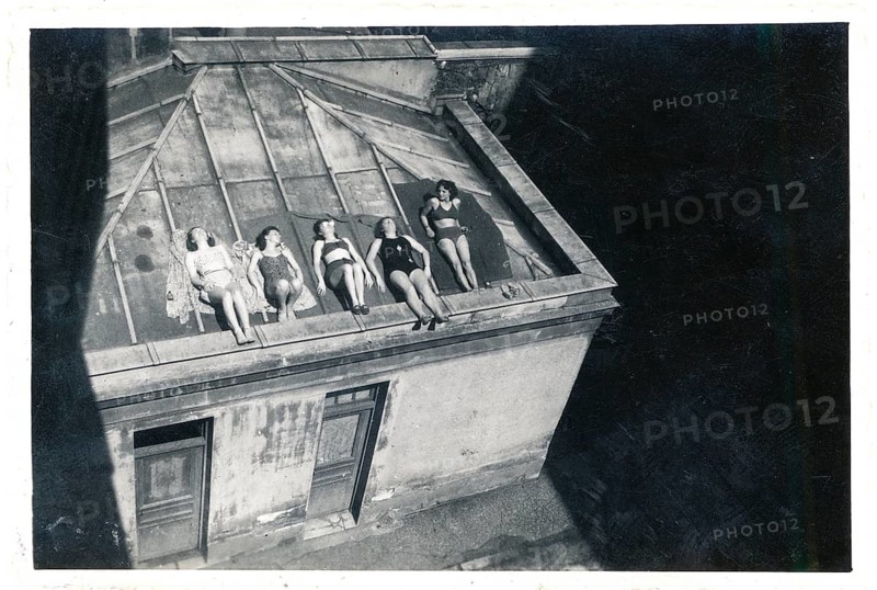 Bathing, swimwear, leisure, summer, woman in bathing suits sunbathing on a sloping flat roof, around 1930