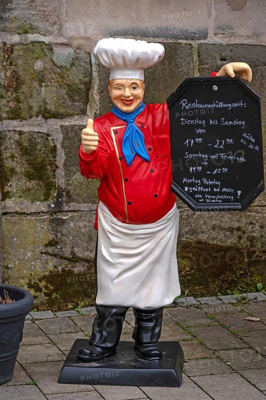 Cooking figure with menu in front of an inn, Altdorf, Middle Franconia, Bavaria, Germany