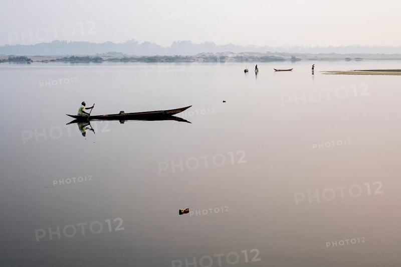 Man boating on the Mahanadi river (Odisha, India), two fishermen in the background