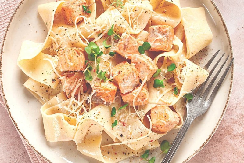 Tagliatelli pasta, with salmon slices and herbs, on a decorative plate, homemade, no people