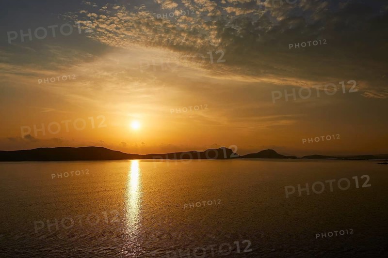A calm sunset over the sea with light clouds in the sky, Navarino Bay, Pylos, Peloponnese, Greece