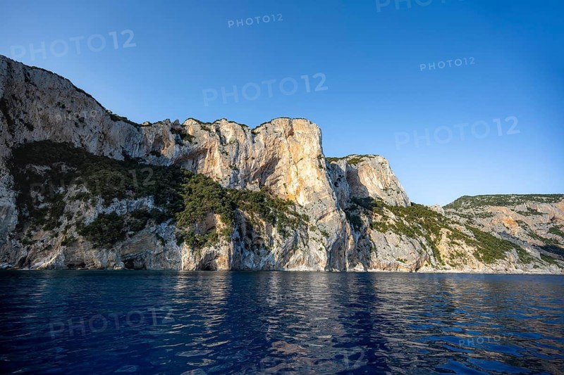 Picturesque rocky coast, cliffs in morning light, blue sea, Golfo di Orosei, Baunei, Sardinia, Italy