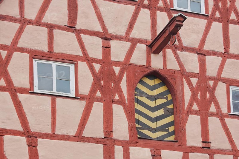 Red half-timbered house with beams and pulley as crane and elevator, window, gate, Herrngasse, Coburg, Upper Franconia, Bavaria, Germany