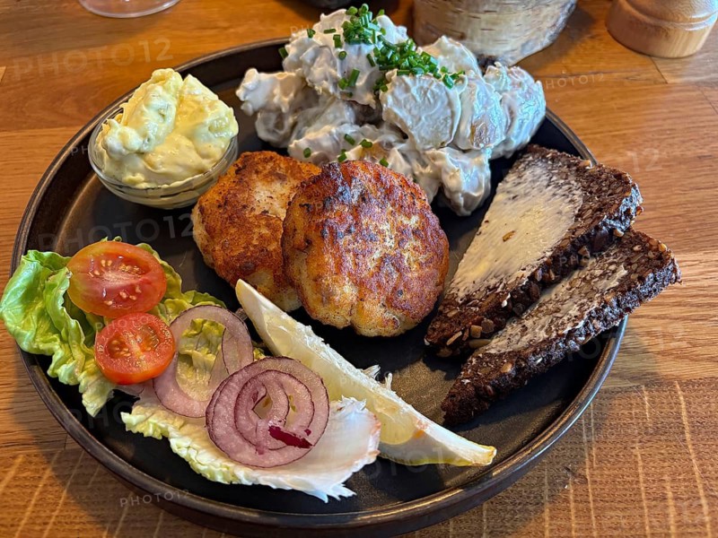 Colourful food on a plate with fish cakes, potato salad and fresh vegetables, Bornholm, Denmark