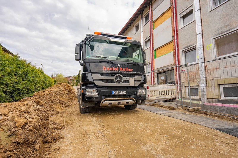 Black truck on a dusty road in a residential area with construction work on buildings, residential renovation, Nagold, Calw district, Germany