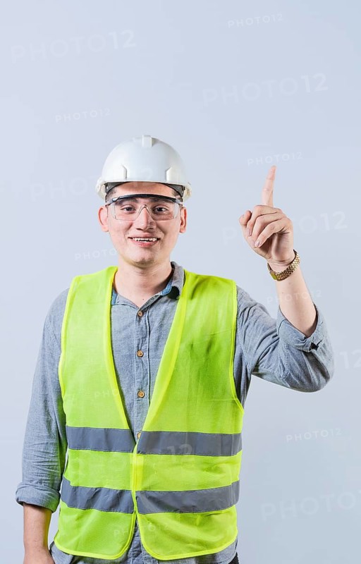 Latin engineer pointing up isolated. Smiling engineer pointing at an advertisement up