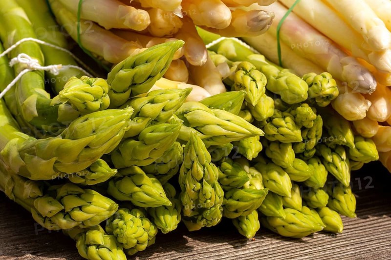 Green asparagus and white asparagus decorated on a rustic wooden table